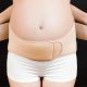 pregnant woman putting on a belly band