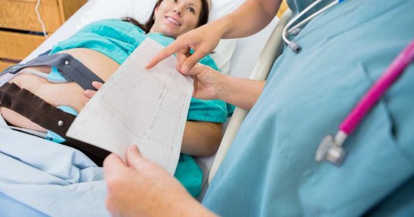 woman and nurses with fetal monitoring strip