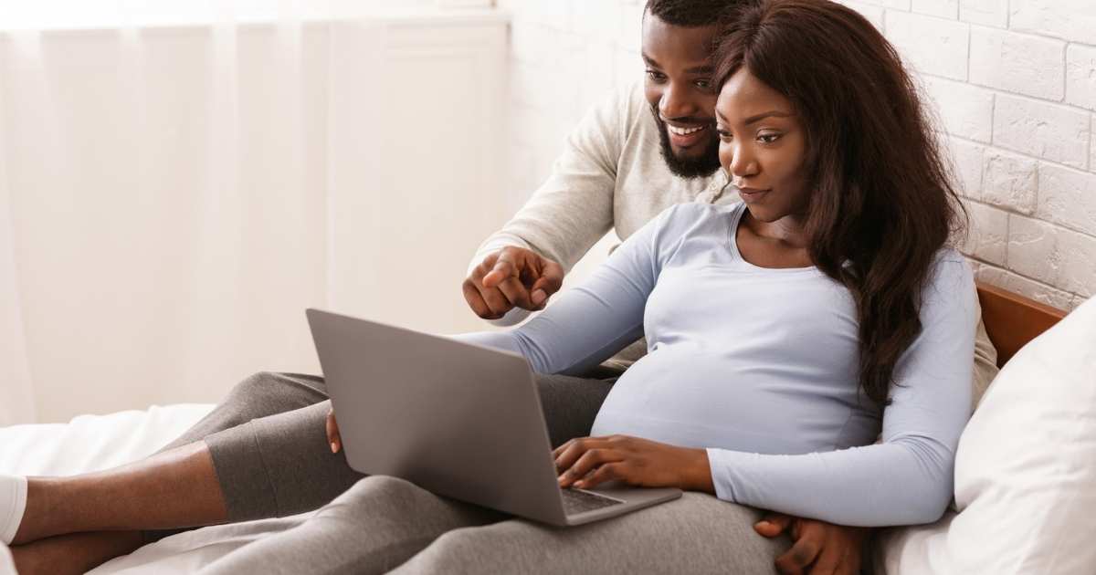 pregnant couple on a laptop