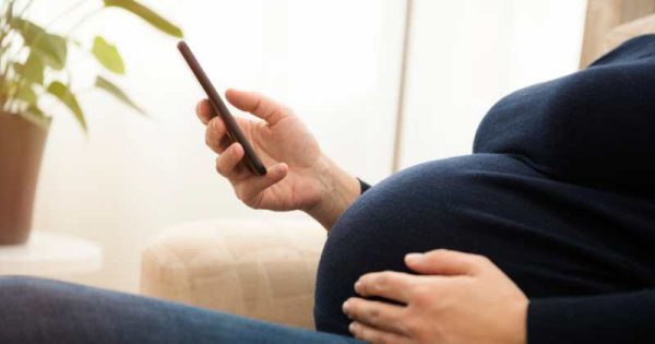 pregnant woman looking at phone