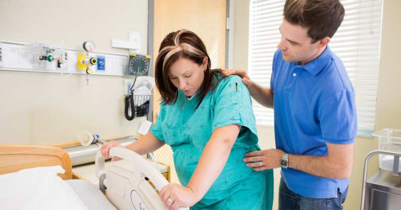 husband helps wife in labor