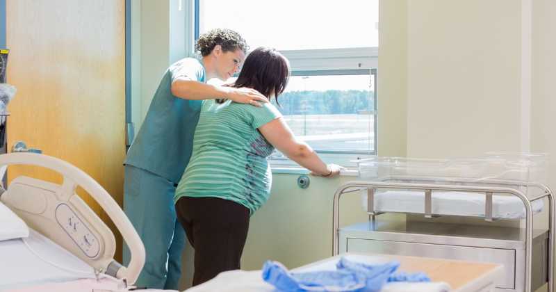 pregnant woman up walking in the hospital with her nurse.