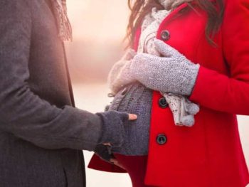 pregnant couple in coats