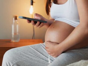 pregnant woman looking at her phone