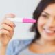 woman looking at a pregnancy test with a positive sign.