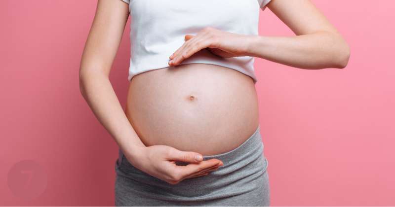 pregnant woman with hands framing belly