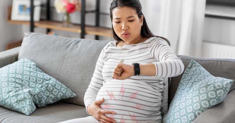 pregnant woman contracting looking at her watch