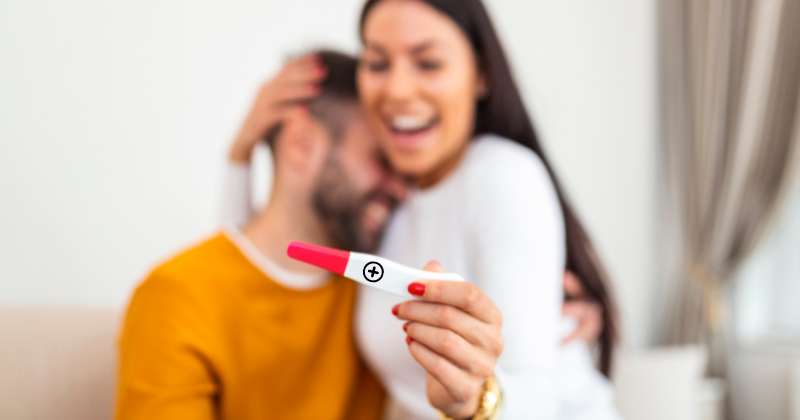 happy couple with a positive pregnancy test.