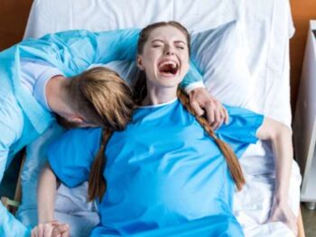 woman with partner screaming in labor