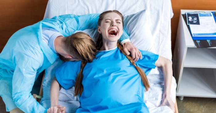 woman with partner screaming in labor