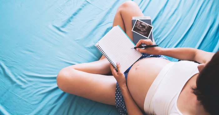 pregnant woman holding a notebook