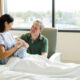 husband and wife in a hospital room with their newborn