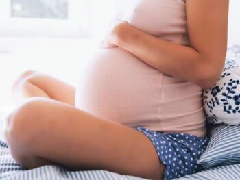 pregnant woman sitting on bed