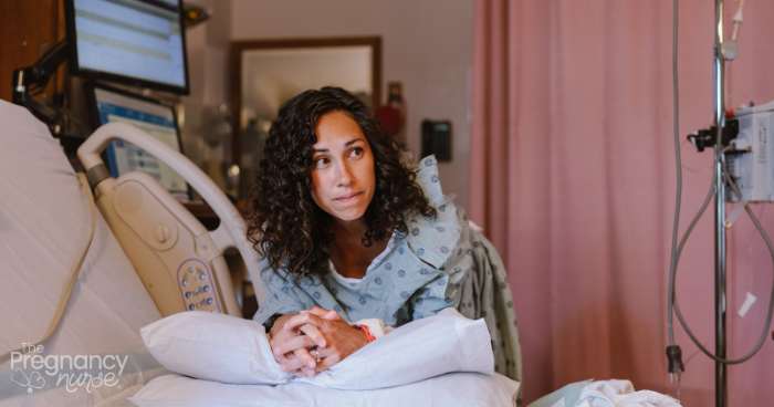 pregnant woman leaning on her bed