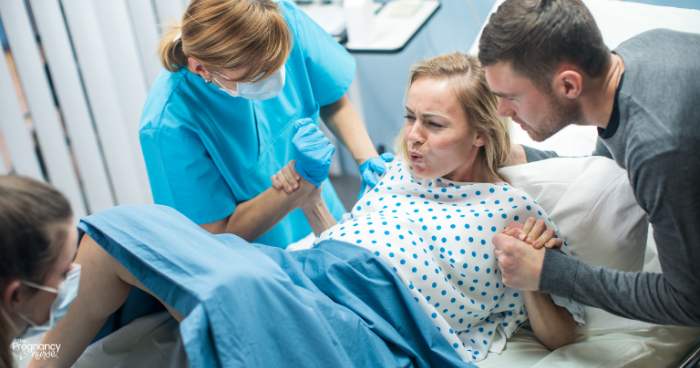 pregnant woman pushing out a baby