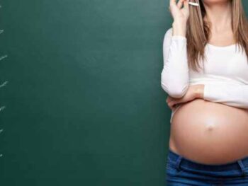 Pregnant woman in front of chalk board