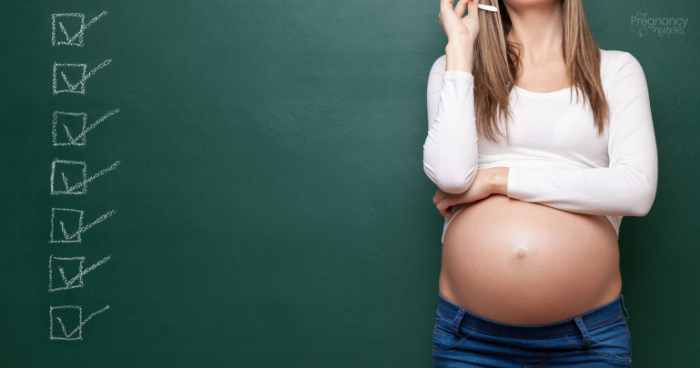 Pregnant woman in front of chalk board