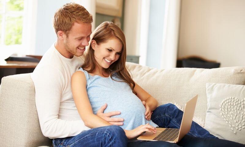 Couple taking online prenatal class together on the couch